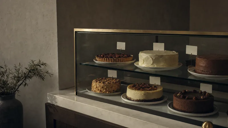 Kuchenvitrine im Café Glasvitrine mit Torten und Kuchen, davor kleine leere Preisschilder