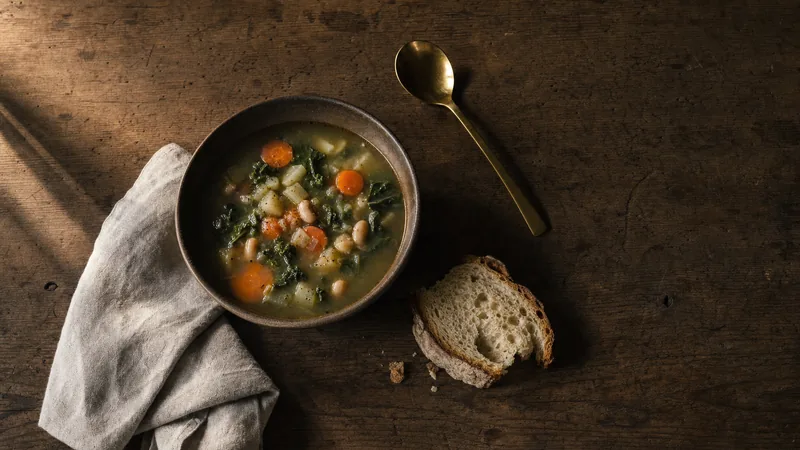 Tagesgericht auf der Karte Schale Gemüsesuppe mit einer Scheibe Brot auf einem Holztisch von oben